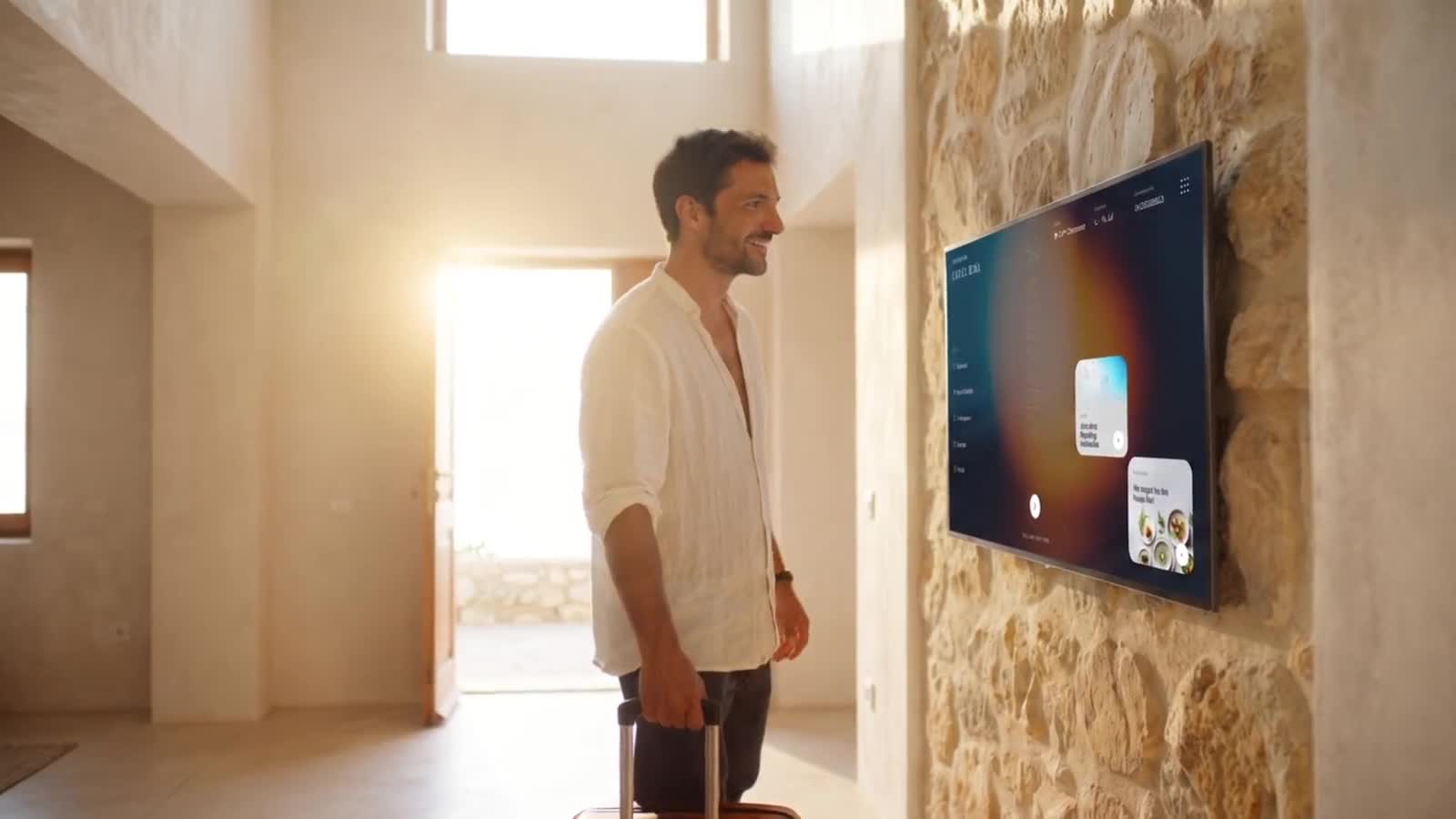 Gast vor dem Wand-Screen im Eingang der Villa